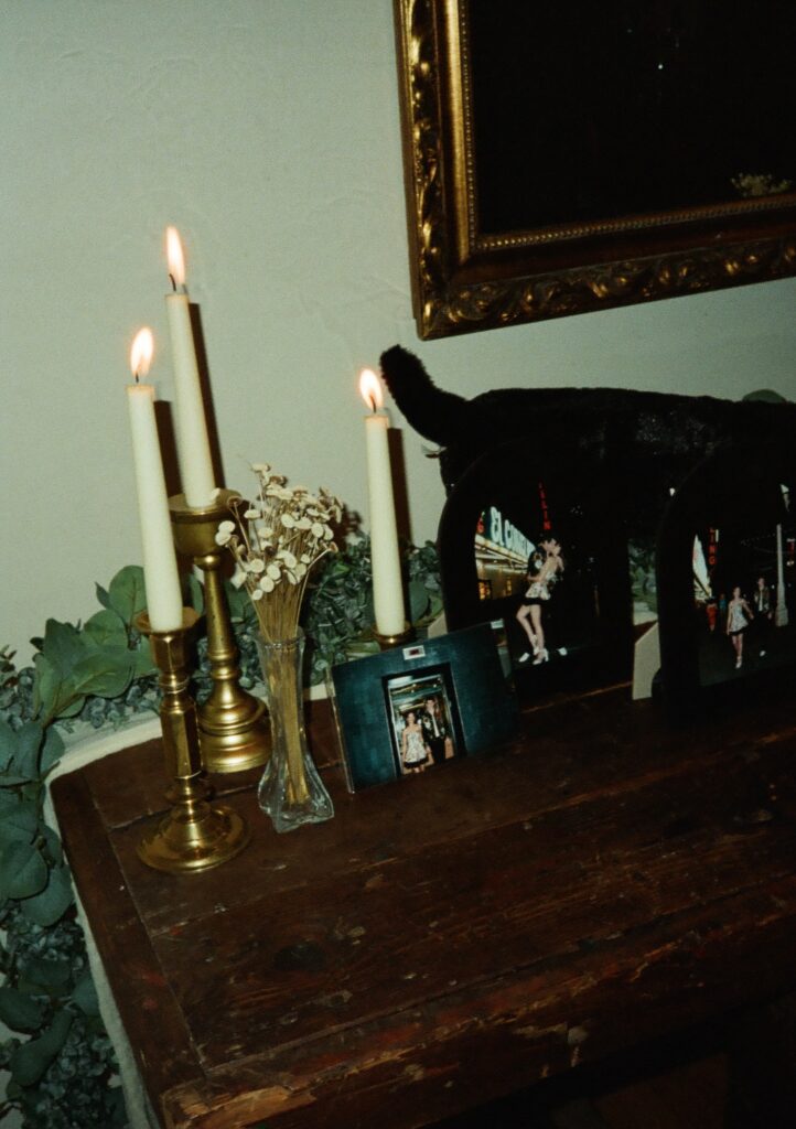 35mm film photo of lit candles on a wood table