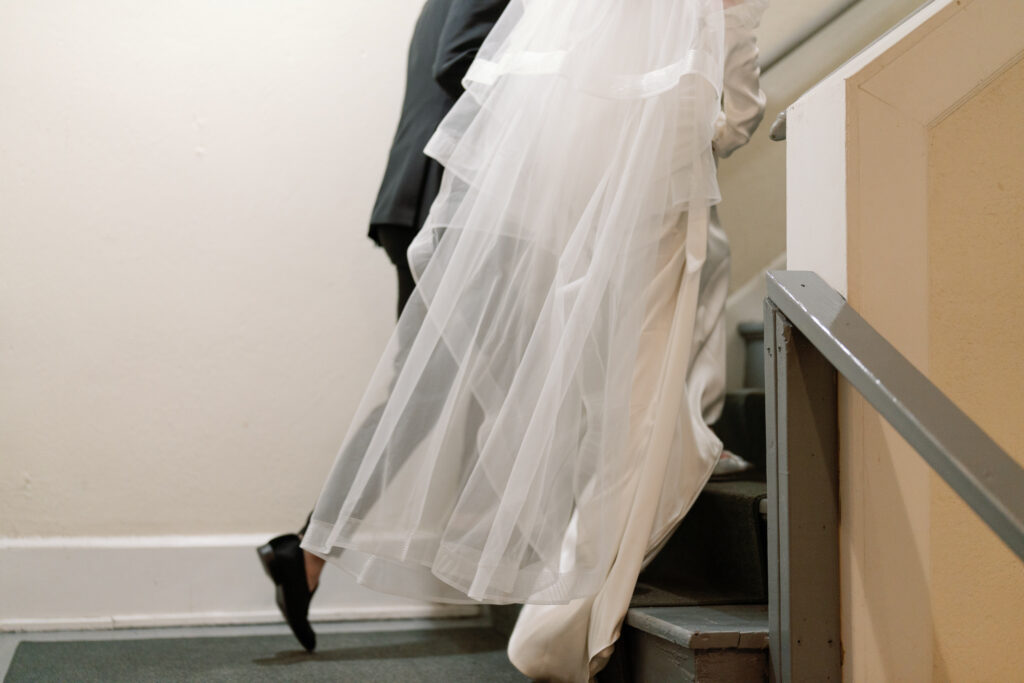 bride and groom quickly walking up stairs