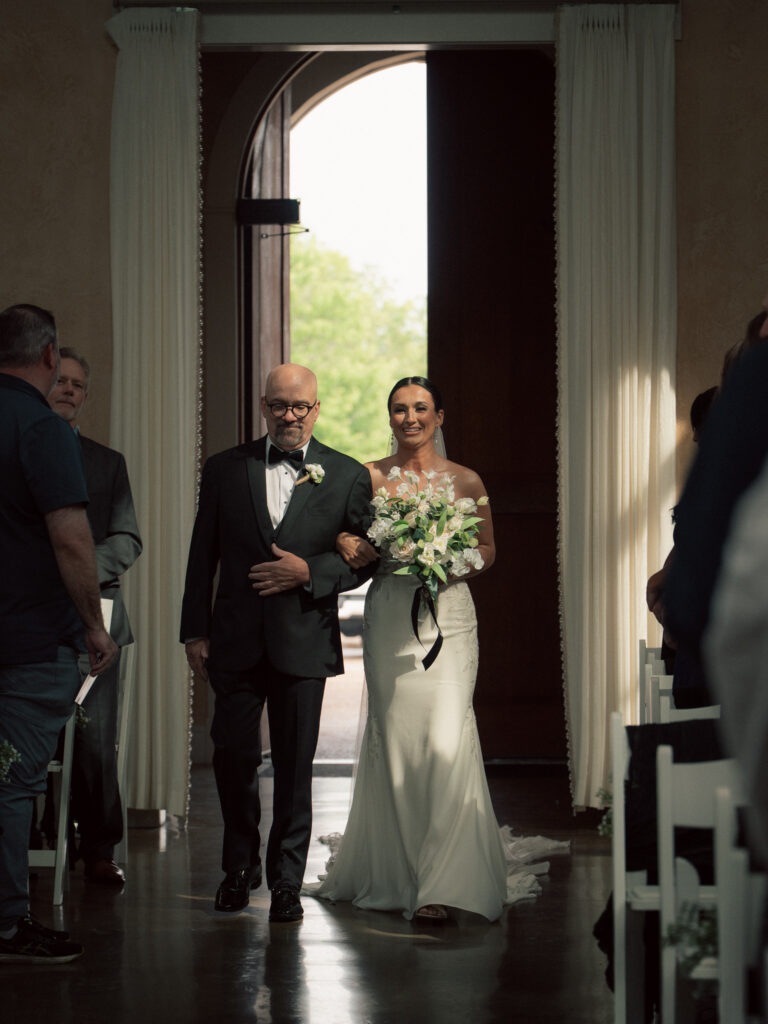 Bride walking down the aisle with father at indoor wedding ceremony at the Chapel - The Marquee at New Town