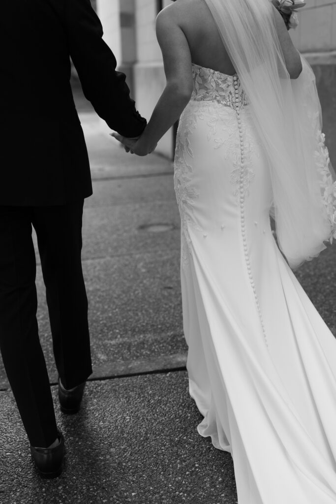 Bride and groom holding hands walking away after ceremony at The Marquee at New Town