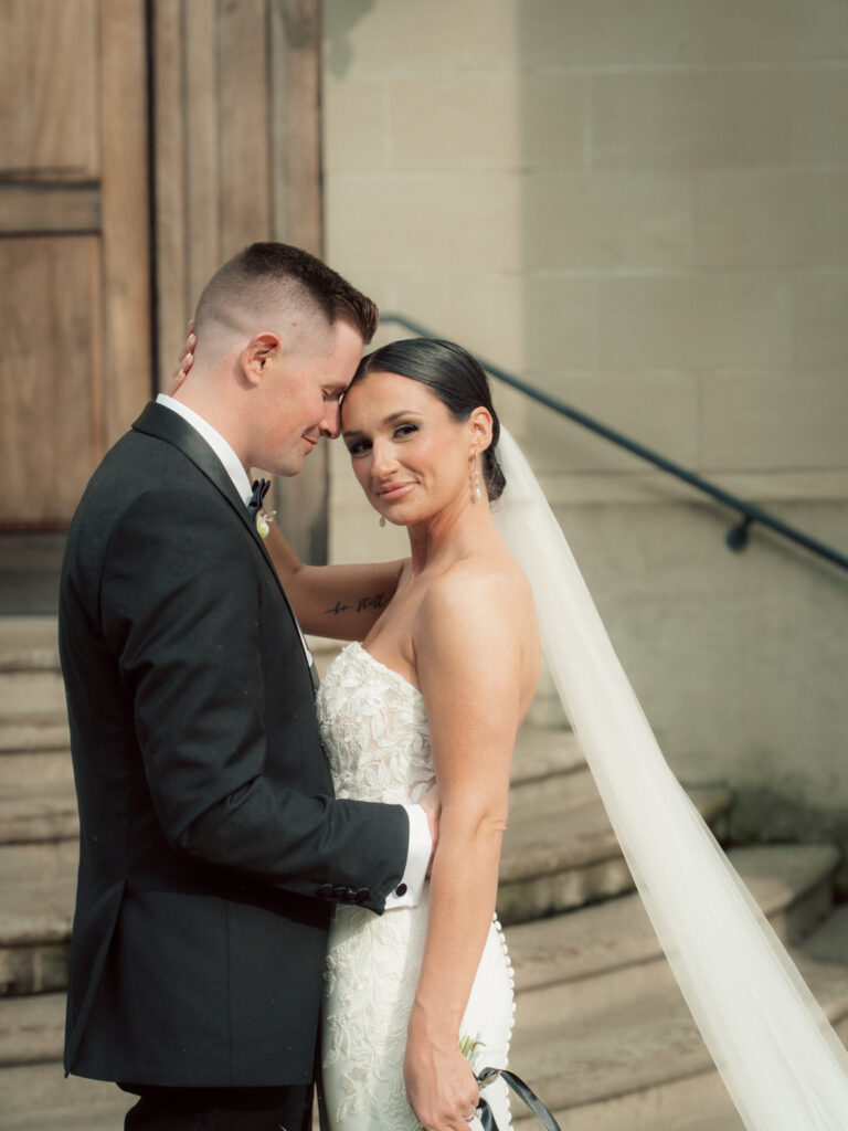 Bride and groom embracing outside church steps at The Marquee at New Town in St. Louis
