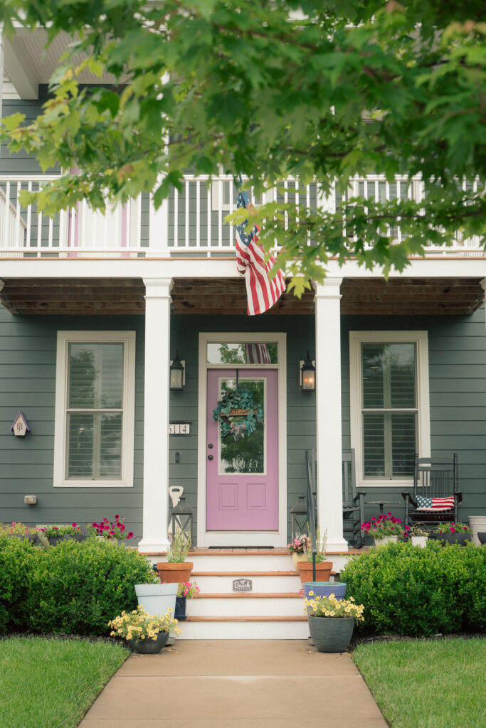 Charming front porch with lavender door and American flag in New Town St. Charles neighborhood