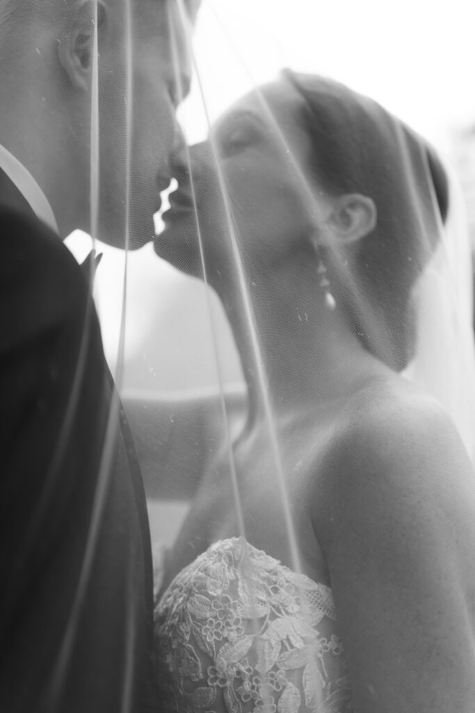 Bride and groom kissing under veil in soft, romantic wedding portrait at The Marquee at New Town